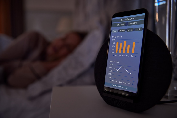 woman sleeping in bed with sleep data app running