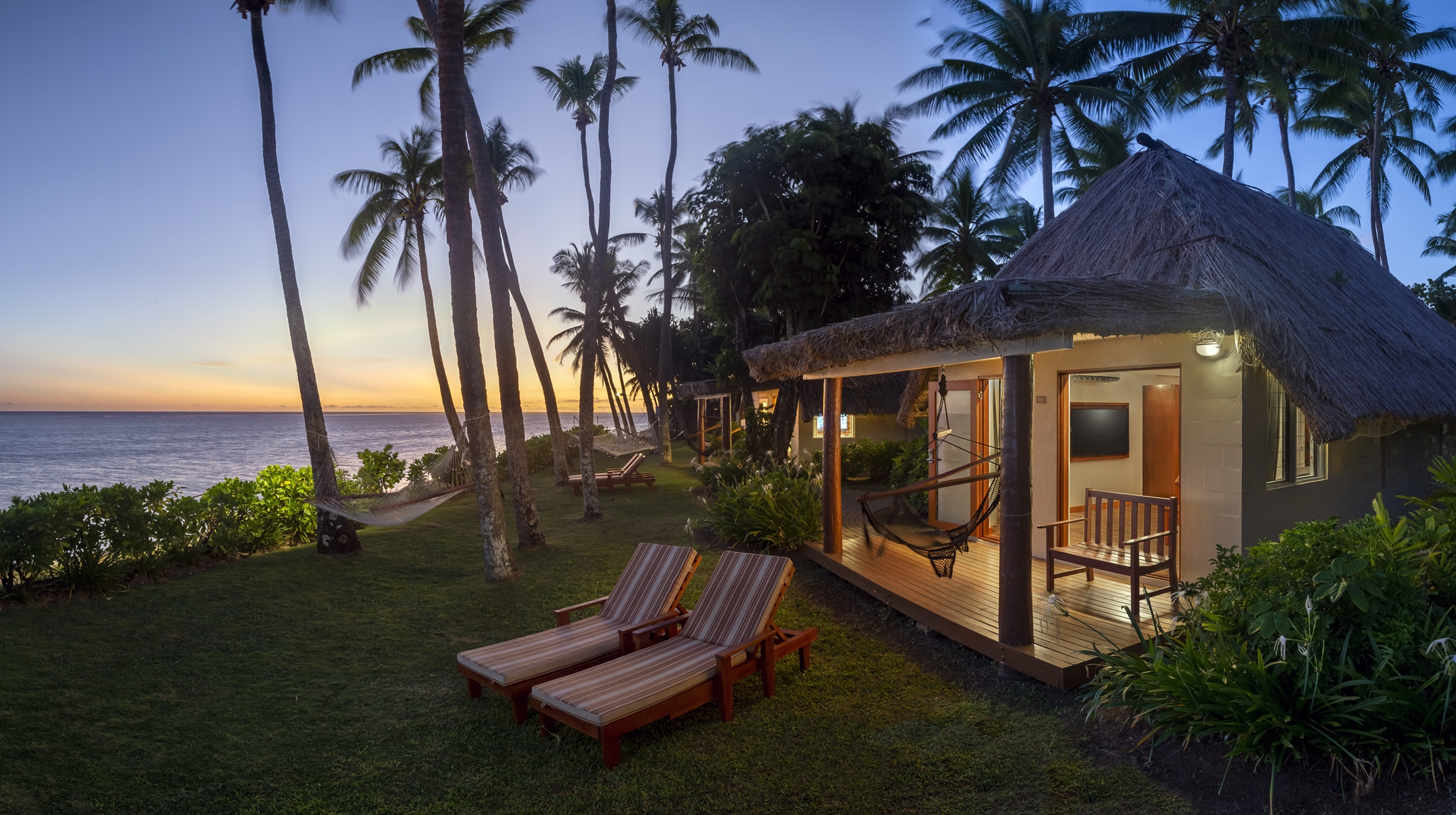 The Beachfront Bures at Outrigger Fiji Beach Resort are nestled amid palm trees, directly on the sandy shore